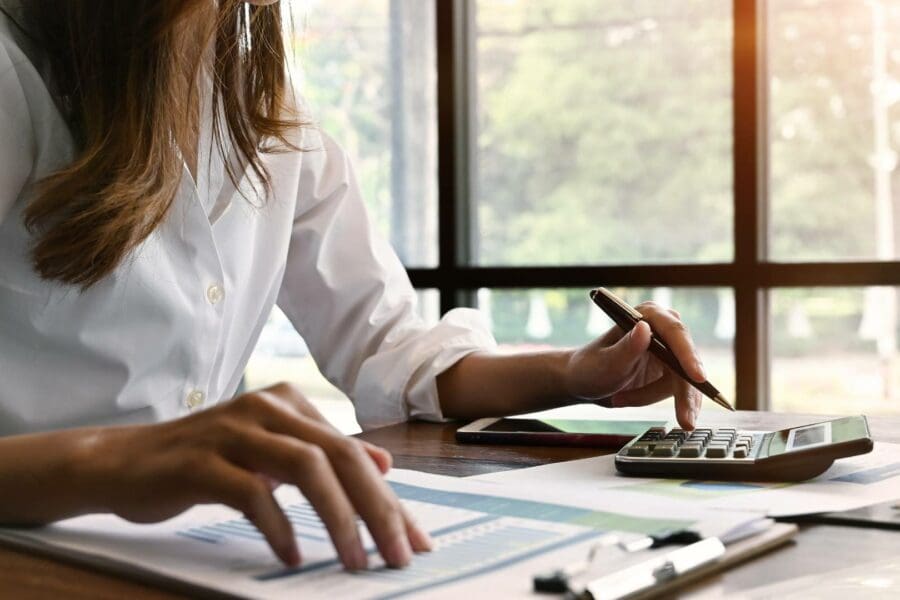 A businesswoman at a desk calculating