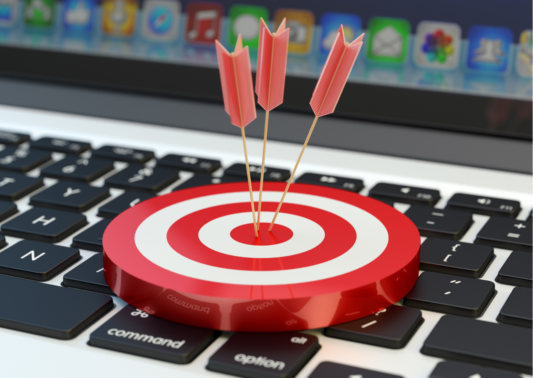 A laptop keyboard with a bullseye target on the keys. There are 3 red arrows stuck in the bullseye.